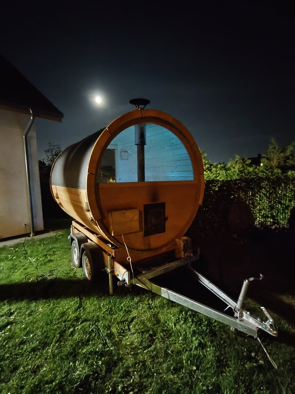 Sauna mobilna ustawiona w ogrodzie po zmroku